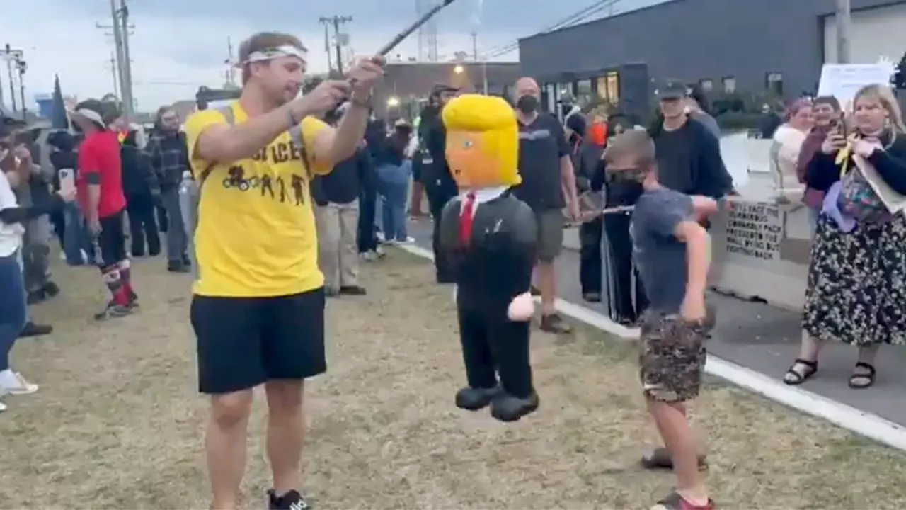 Child at 'No Kings' protest stabs at Trump piñata