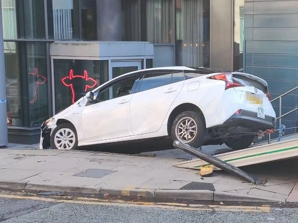 Taxi flips over and crashes down footsteps outside Manchester city centre hotel